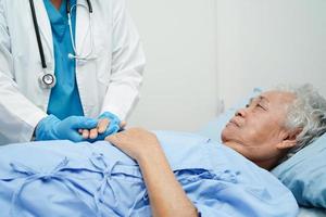 médico tomados de la mano paciente anciana asiática, ayuda y atención en el hospital.