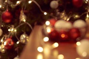 Decorated Christmas tree on blurred, sparkling and fairy background photo