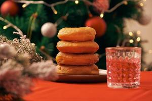 Christmas interior of kitchen with wooden table and donuts and blurred xmas tree decoration photo