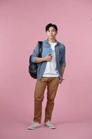 happy smiling student standing with backpack and folders over pink background photo
