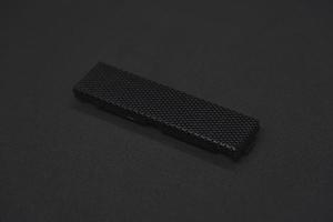The iron panel from the computer. Iron black mesh panel. Metal rectangular panel on a black background. Beautiful iron rectangular black shape. photo