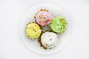 Delicious colorful cakes on a plate. Cream cakes on a white background. Shortbread cakes. photo