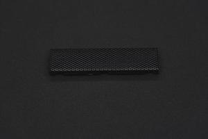 The iron panel from the computer. Iron black mesh panel. Metal rectangular panel on a black background. Beautiful iron rectangular black shape. photo