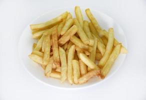 Yellow delicious French fries in white dishes. Fast food on a plate. Fried potatoes. Toasted potato slices on a white background. photo