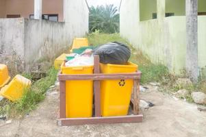 Yellow garbage can or dusbins served for recycled garbage in the village in Thailand photo