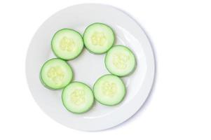 Top view of fresh cucumber slices on white plate or dish isolated on white background with clipping path photo