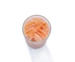 Top view of orange Thai  iced condensed milk tea in transparent glass isolated on white background with clipping path photo