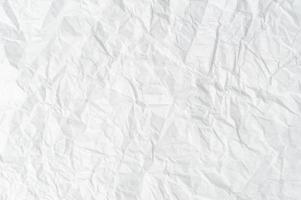 Wrinkled or crumpled white stencil paper or tissue after use with large copy space used for background texture photo