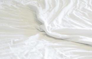 sábana blanca arrugada tomada en la habitación del hotel con espacio para copiar, textura de fondo de manta foto