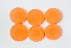 Fresh orange sliced carrots in stack isolated on white background photo