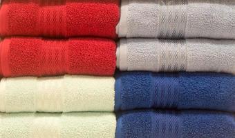 Beautiful colorful bath towels tidily folded on shelves in department store used as pattern background photo