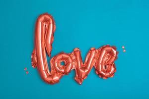 Red baloons Love shape on turquoise background. Valentines Day concept. photo