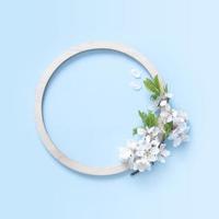 Round wooden frame with flower and leaves mock up flat lay for your text photo