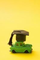 Toy mini car with a graduated cap. Driving leaning concept photo