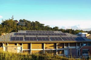 A solar roof system in a building that installs solar panels on the roof of the building. To generate electricity, which will save electricity and reduce global warming. photo