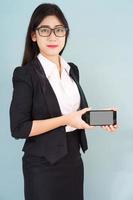 Young women in suit holding her smartphone photo