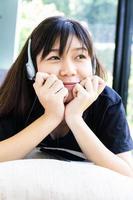 Teenage girl with headphones and listening to music photo