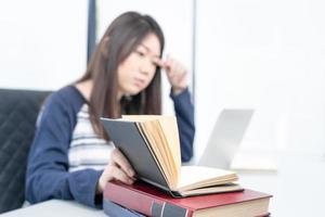 Young female sitting in living room and learning online photo