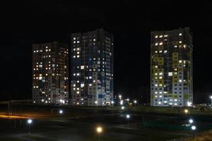 panorama nocturno de luz en las ventanas de un edificio de varios pisos. la vida en una gran ciudad foto