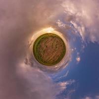 tiny planet in blue sky with beautiful clouds. Transformation of spherical panorama 360 degrees. Spherical abstract aerial view. Curvature of space. photo