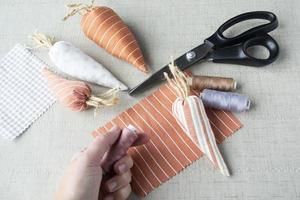 mano de anciana sosteniendo un carrete de banda de rodadura, costura y costura de pascua, artesanía fácil y creativa para la familia, decoración del hogar de pascua foto