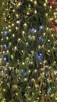 Closeup branches of coniferous tree decorated with glittering balls and shiny garland. Selective focus. Perfect festive content for stories background, vertical banner. photo