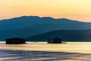 landscape sunset with Reservoir and raft house Thailand photo