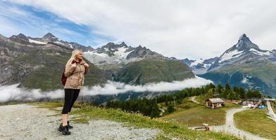 Traveler in the Alpine meadow, Switzerland photo