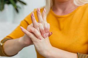 dolor en las articulaciones de las manos. cuidado de manos femeninas foto