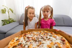 little bored girls eating pizza at home photo