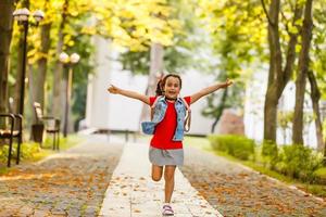 Child going back to school. Start of new school year after summer vacation. Little girl with backpack and books on first school day. Beginning of class. Education for kindergarten and preschool kids. photo