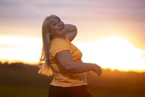 Portrait of a European middle-aged woman in a tracksuit, posing for the camera, relaxing. excited overweight woman in trendy tracksuit resting after exercising. photo