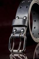 Black leather belt on a dark background. Leather products. photo