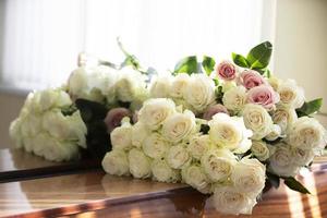 Bouquet of white roses that lie on the piano. photo