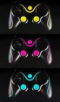 Three gaming joysticks, on yellow-cyan-Magenta and black background. photo