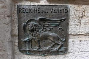 The Lion of Saint Mark, representing the evangelist St Mark, pictured in the form of a winged lion holding a Bible, is the symbol of the city of Venice, Italy. photo