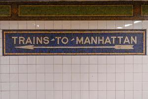 Trains to Manhattan mosaic arrow sign in the  NYC Subway.