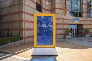Blue and yellow frame with UCLA text displayed in front of college building photo
