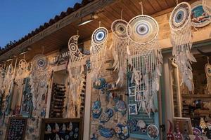 Various dreamcatchers and souvenirs hanging for sale at shop in market photo