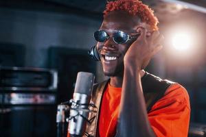 tener práctica vocal. joven intérprete afroamericano ensayando en un estudio de grabación foto