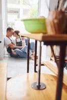 Taking a break and sitting on the floor. With her boyfriend or husband. Young female ceramist indoors with handmade clay product. Conception of pottery photo