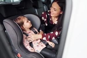 Mother with her daughter inside of modern automobile together photo