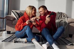 Young lovely couple together at home playing video games at weekend and holidays time together photo