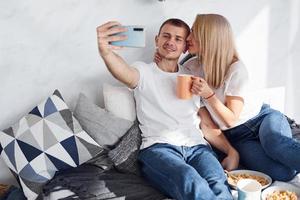 Man holding phone and making selfie of himself and his girlfriend photo