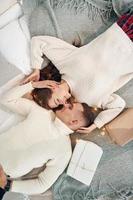 Top view of young romantic couple that lying down and celebrates New year together indoors photo