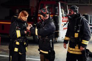 vistiendo uniforme de protección. grupo de bomberos que está en la estación foto