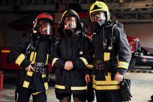 grupo de bomberos con uniforme protector que está en la estación foto