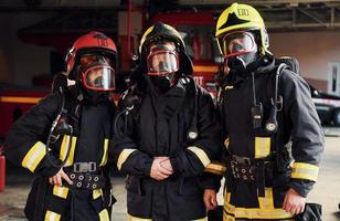 grupo de bomberos con uniforme protector que está en la estación foto