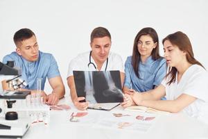 grupo de médicos jóvenes está trabajando juntos en la oficina moderna foto