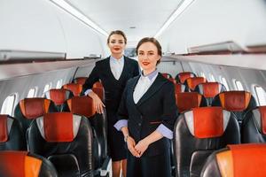 dos azafatas en el trabajo en el avión de pasajeros foto